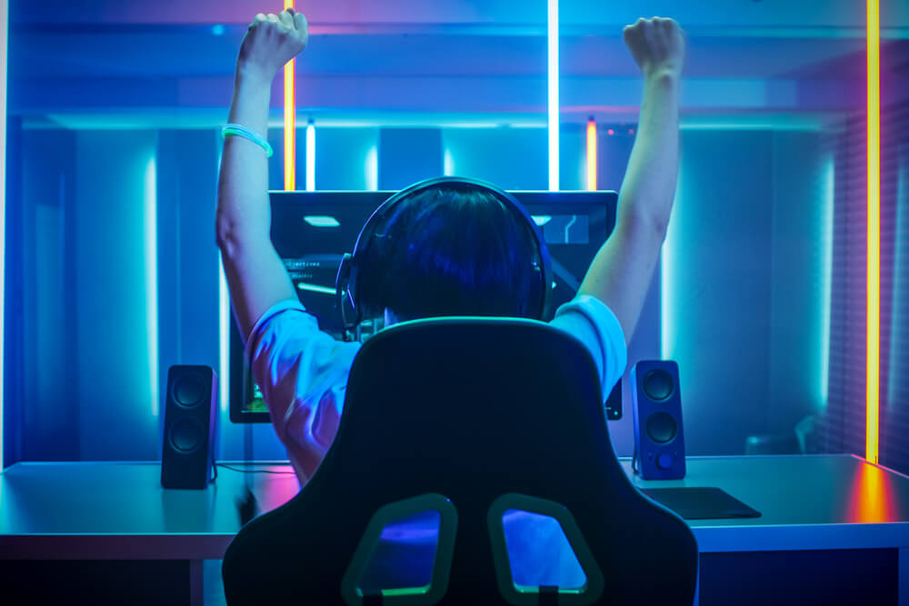 gamer in neon lit room desk
