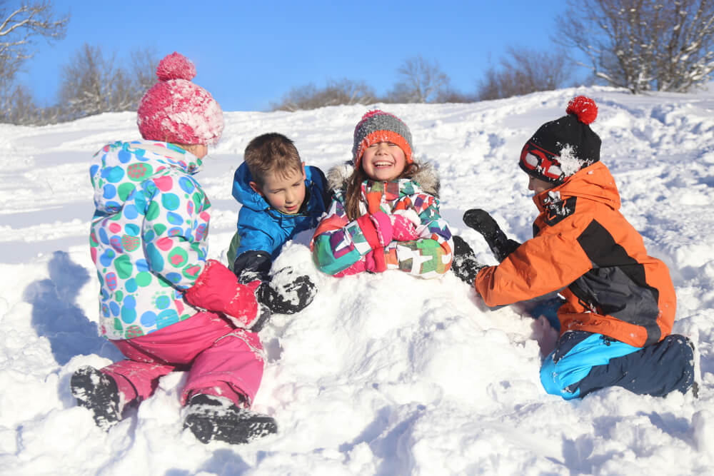 young children playing together in snow