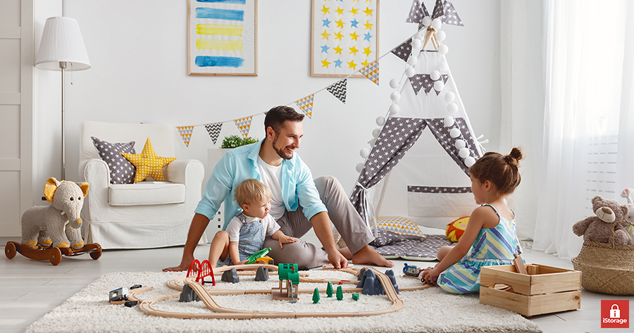 father with two children, playing with toys in the room