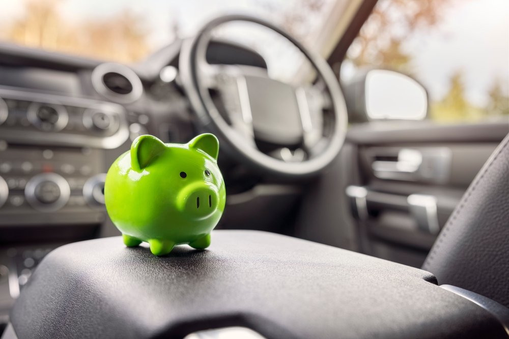 small green piggy bank on a center console in a car