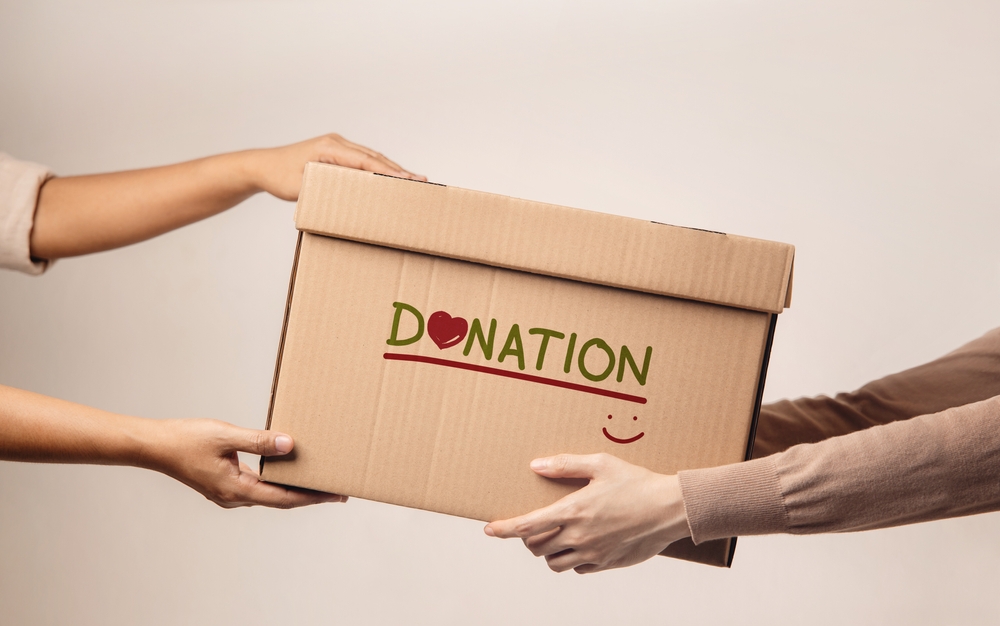 person handing another person donation box