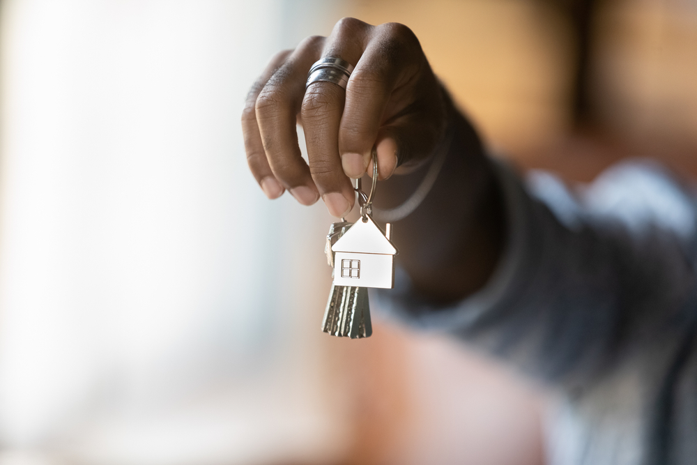 Young African American holding keys to new house