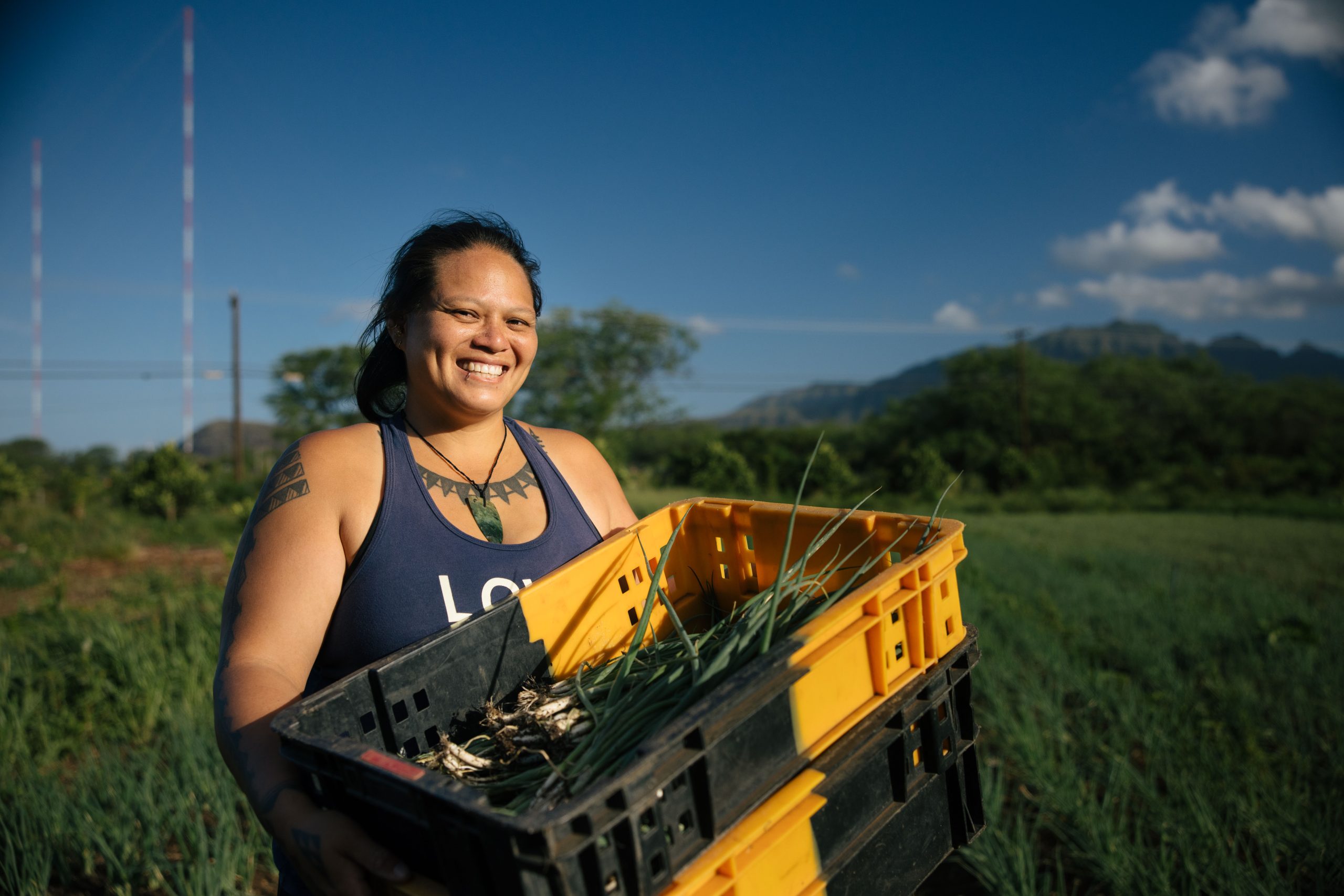 Woman from Hawaii holding basket of produce and smiling