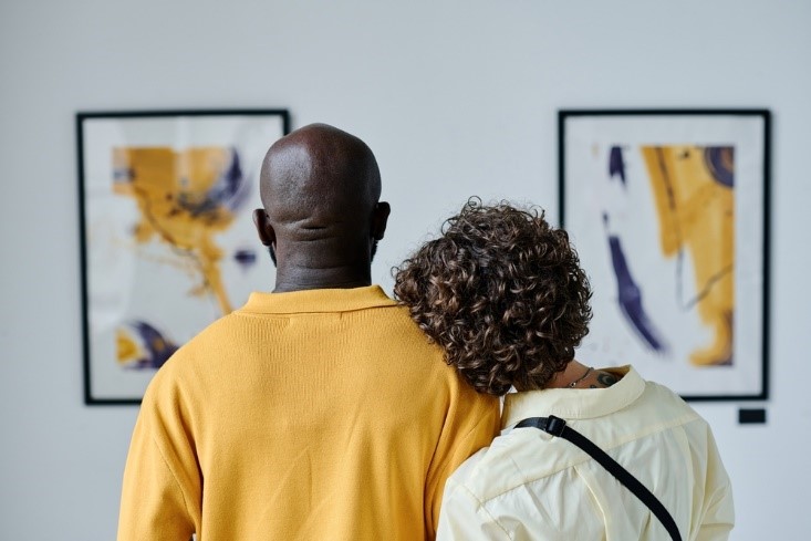 african american couple looking at paintings with yellow tones